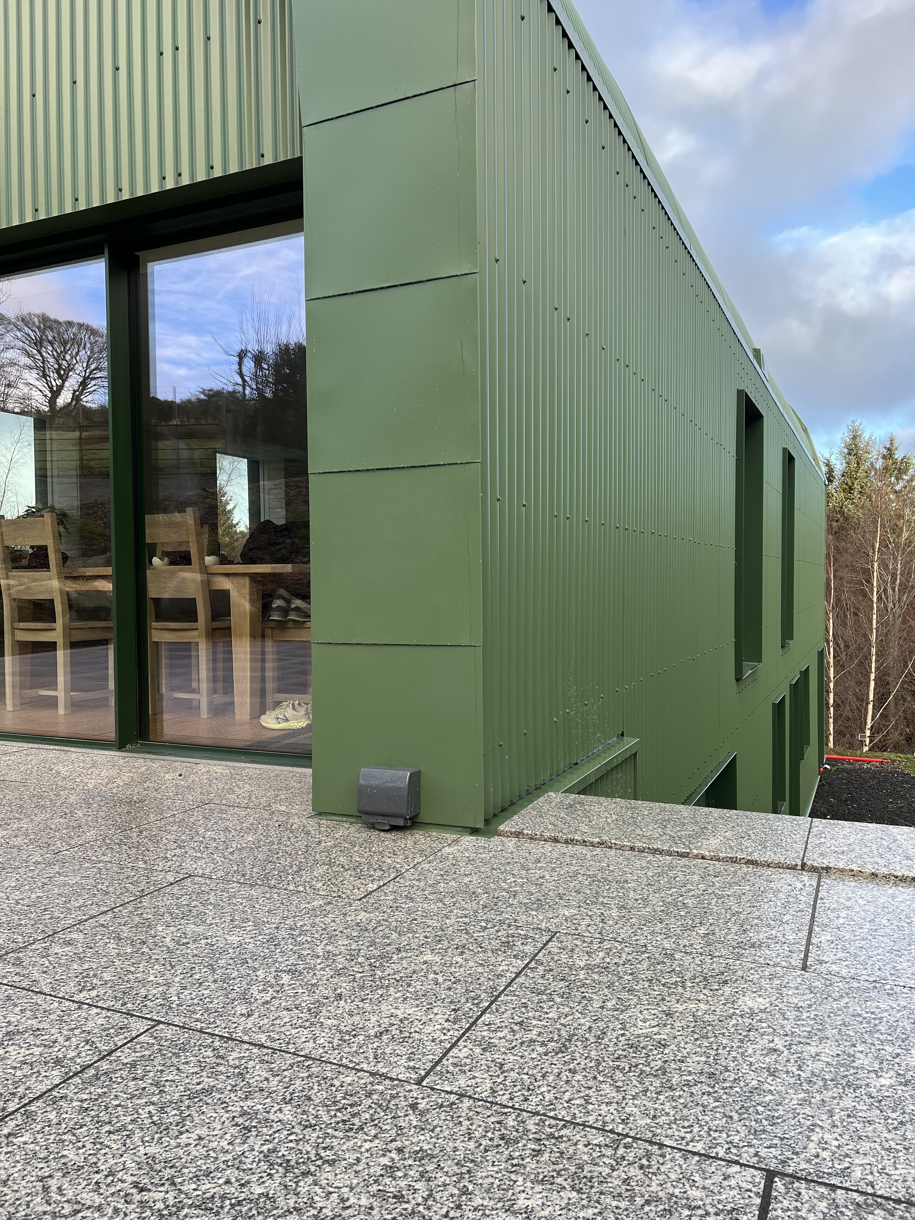 Contemporary green corrugated barn with expansive glazing