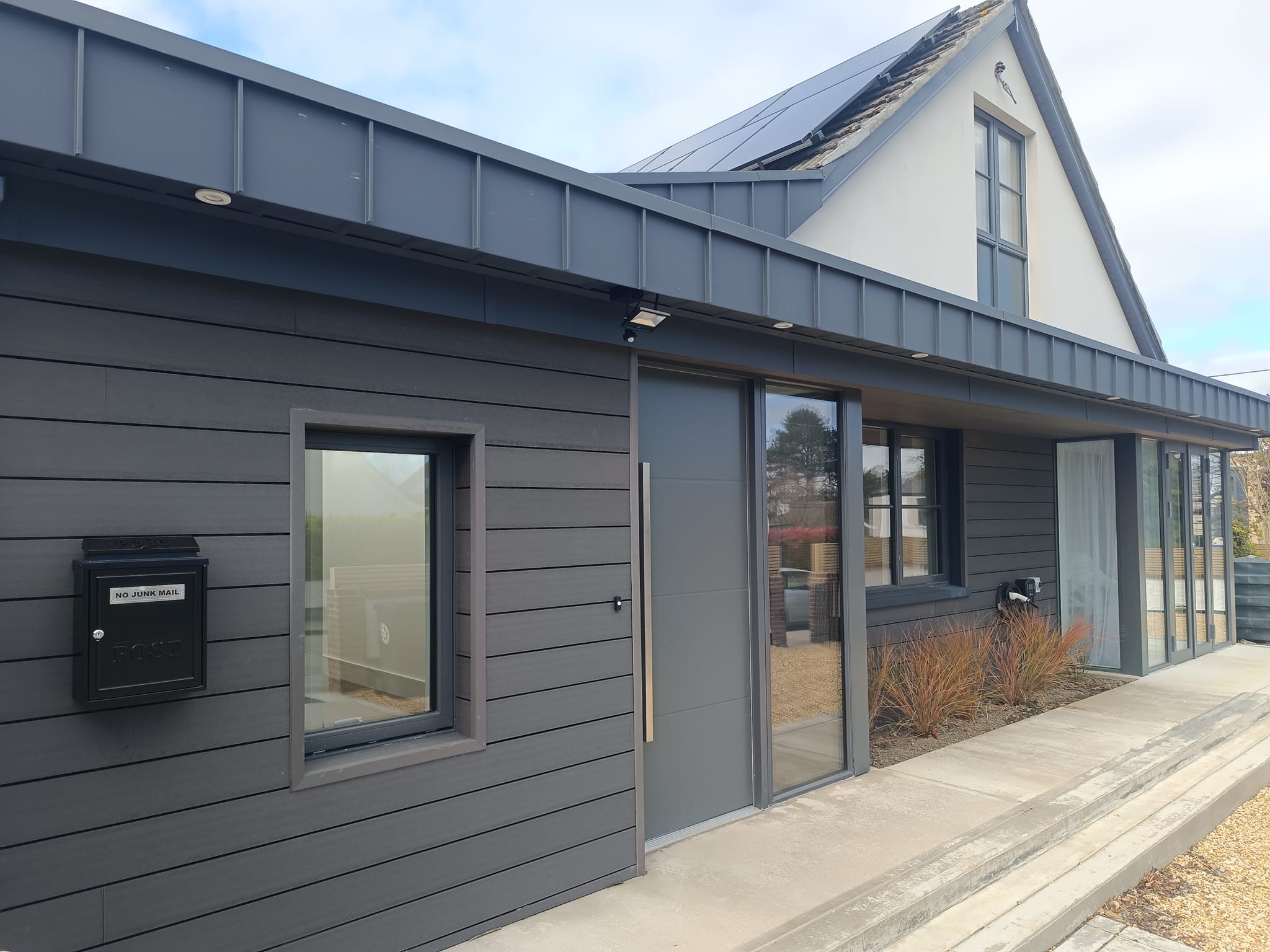 Modern charcoal residence with standing seam roof and glass facade